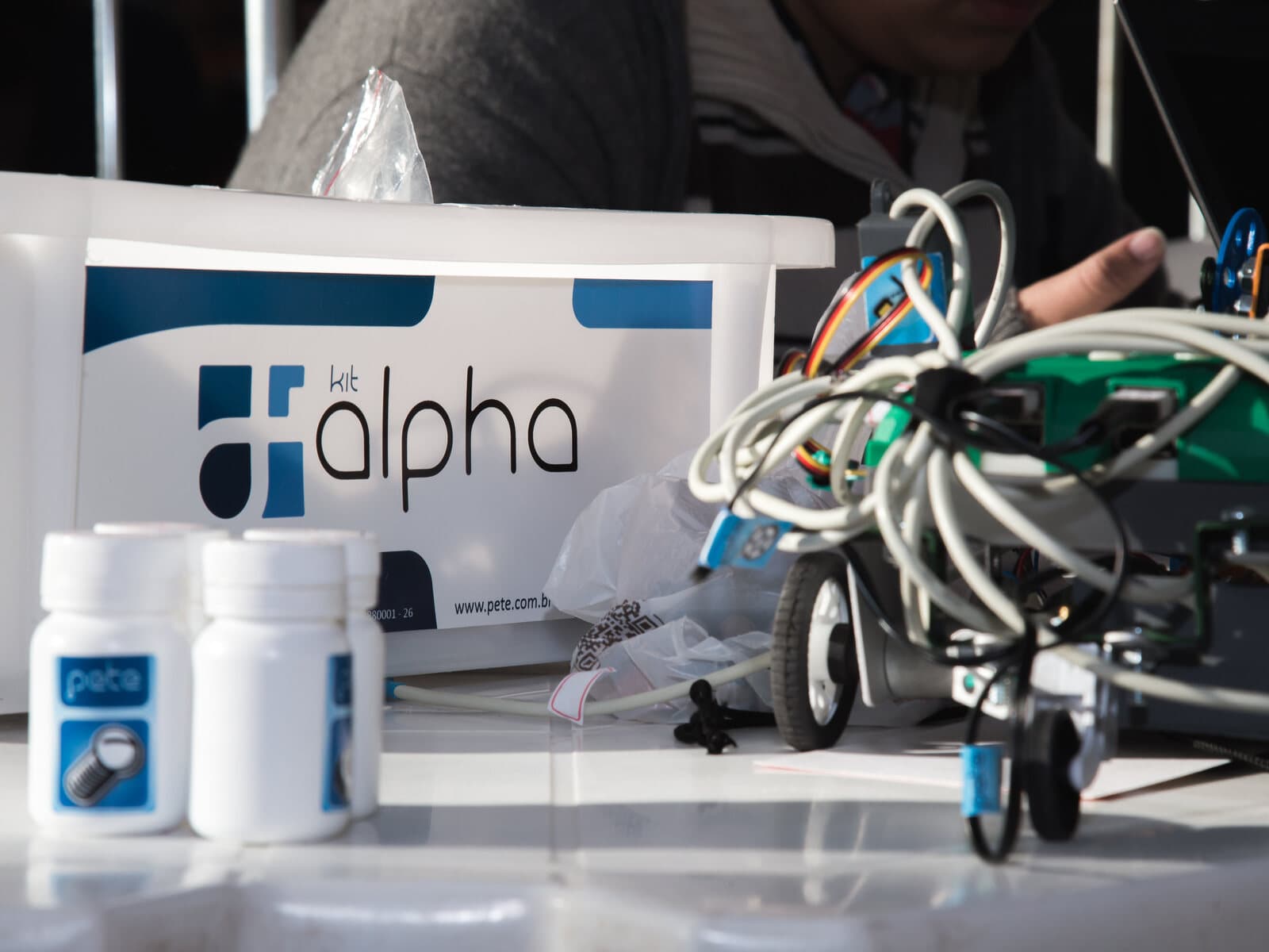 Caixa do kit ALPHA na bancada, com o robô montado e frascos de peças