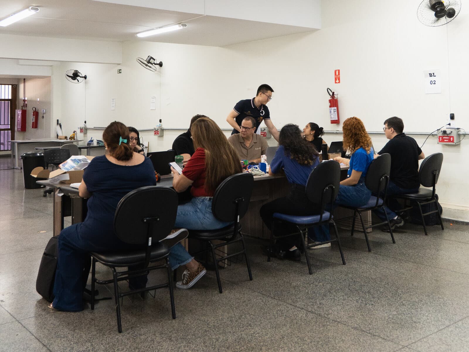 Vista ampla da sala de produção da PETE em São Carlos, com a equipe nas bancadas